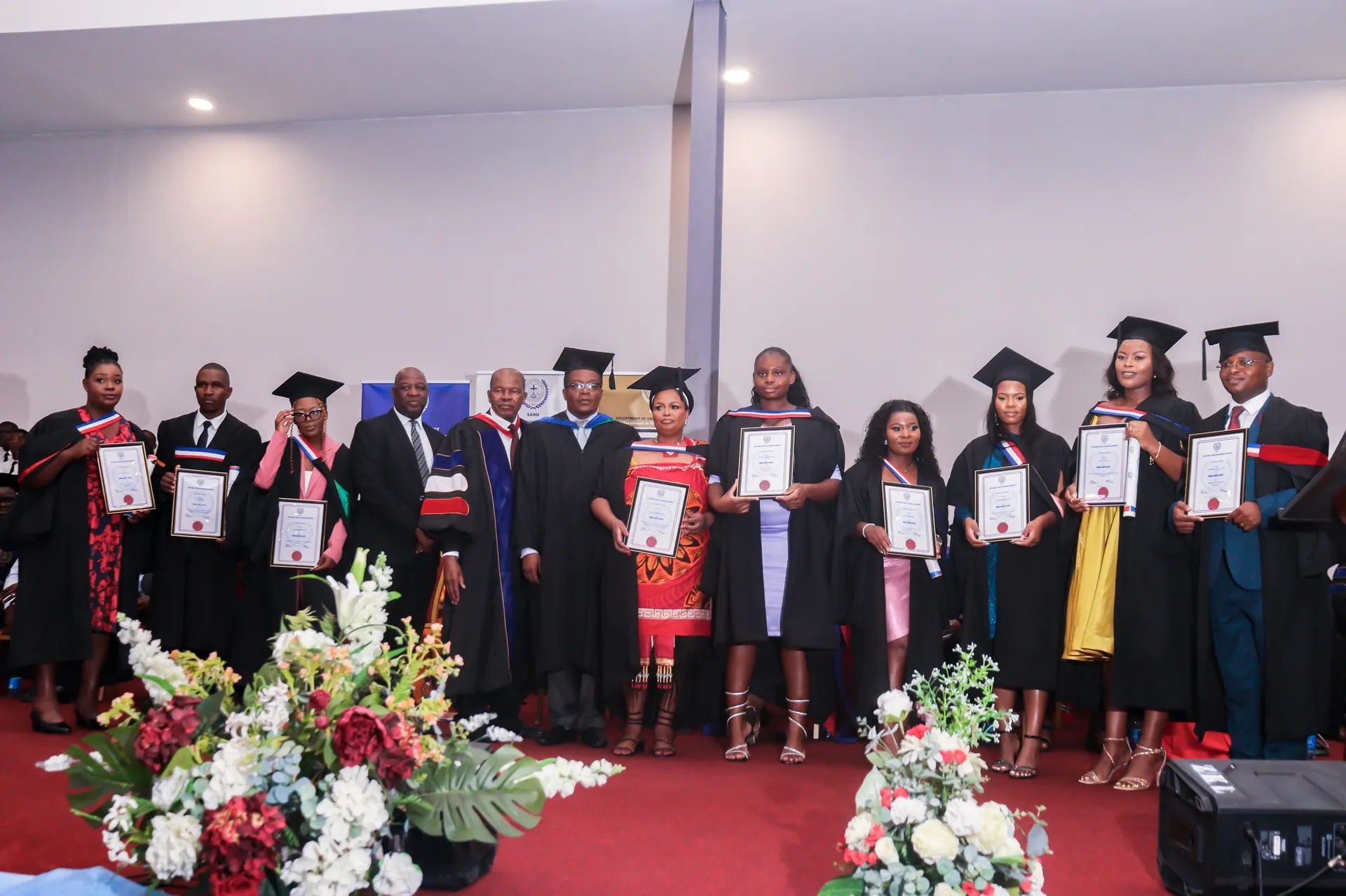 Graduation ceremony with multiple graduates in academic dress.